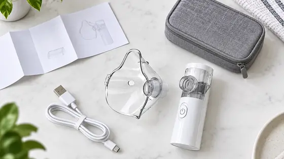 Illustrative nebulizer, mask, cable and storage pouch on a clean planning table