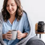 Official Velin photo of an adult seated on a sofa under a grey weighted blanket